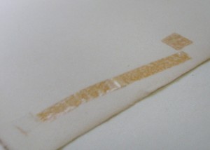 Flecken durch Selbstklebeband vor der Restaurierung Flecken durch Selbstklebeband vor der Restaurierung